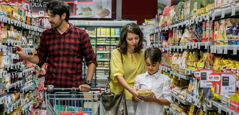 Father, Mother and Son walking through the supermarket shelves of Mega Image.