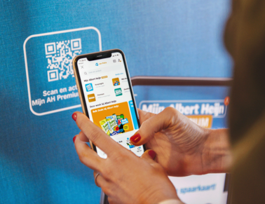 A woman is scanning a QR code with her phone with the Albert Heijn app