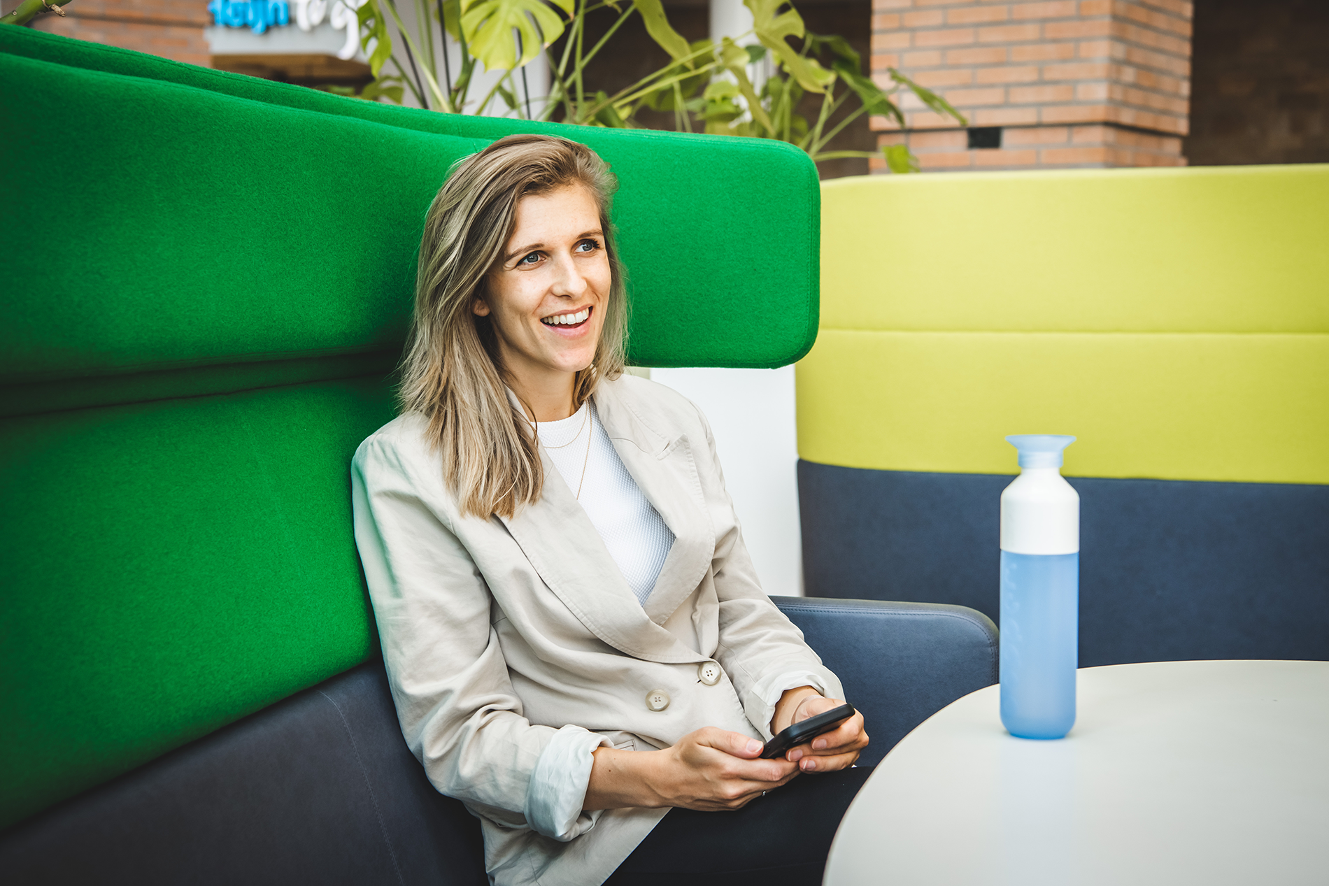 Janneke_smiling_and_sitting_in_green_chair_AholdDelhaize.png